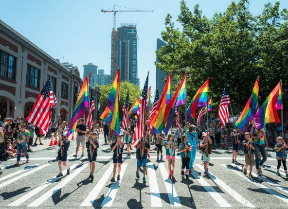 Adults and children hold Pride flags in downtown Seattle